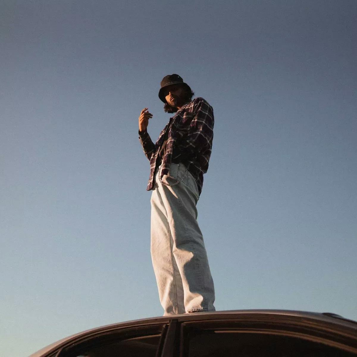Man standing on the hood of a car