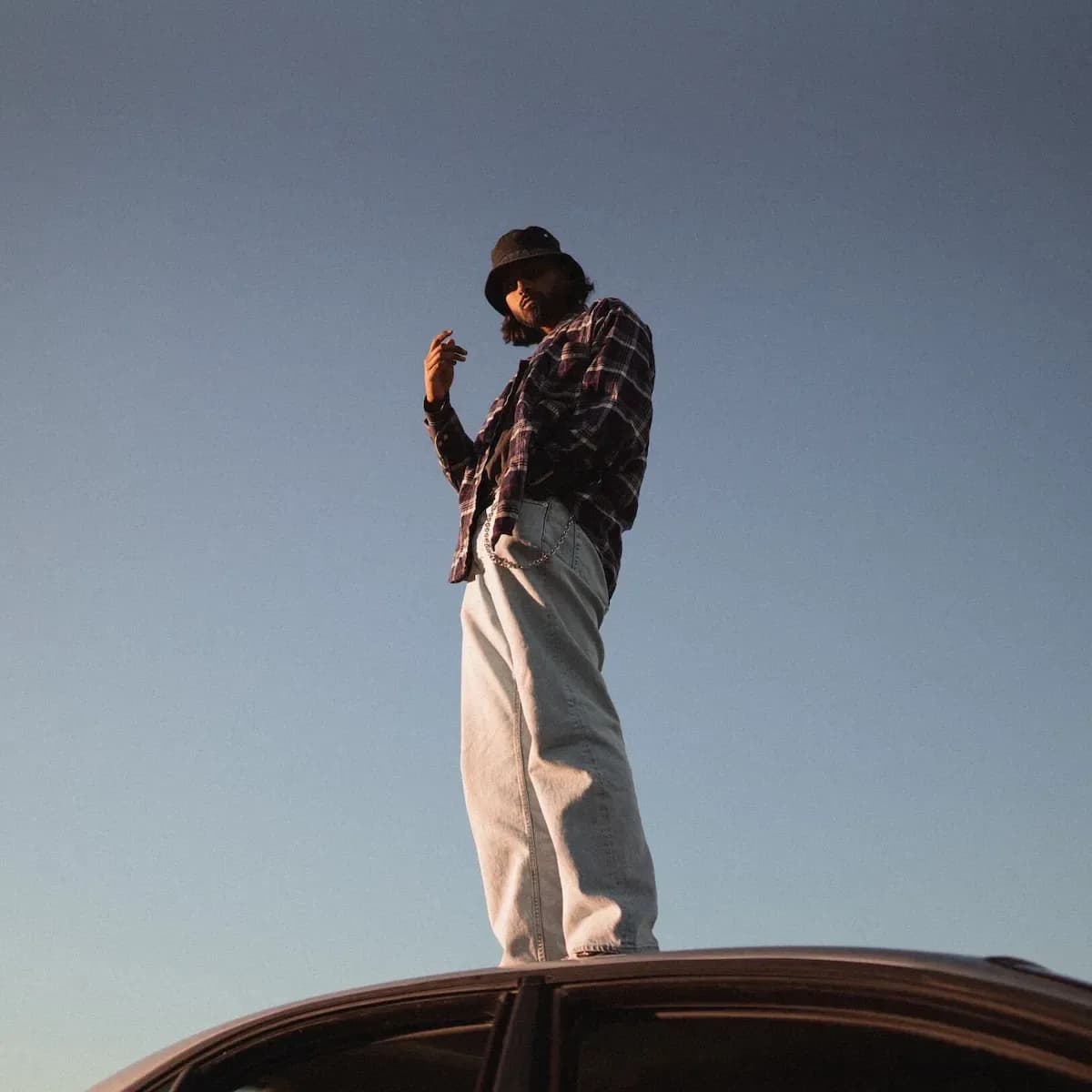 Man standing on the hood of a car