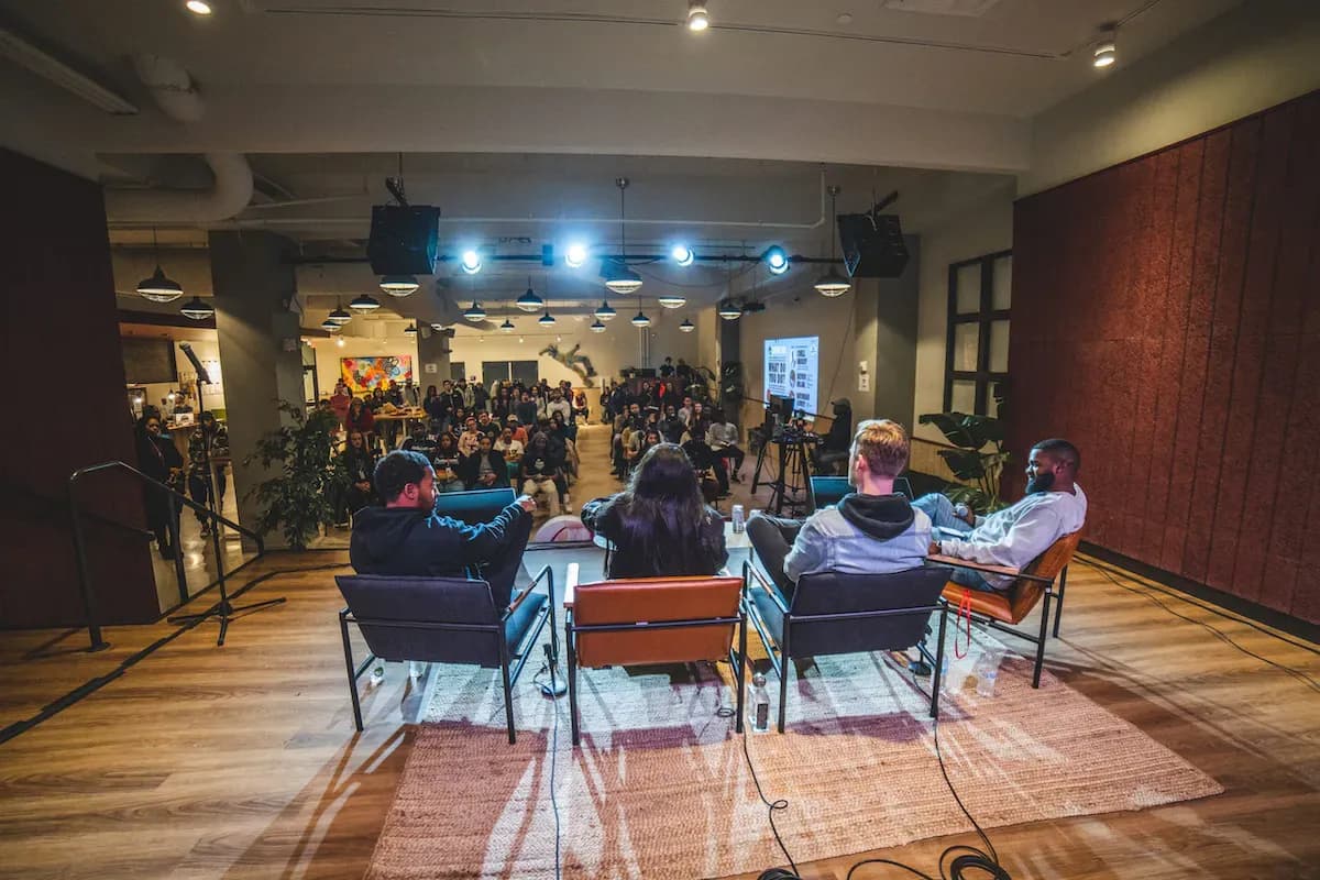 Four people sitting on a panel with their backs facing the camera