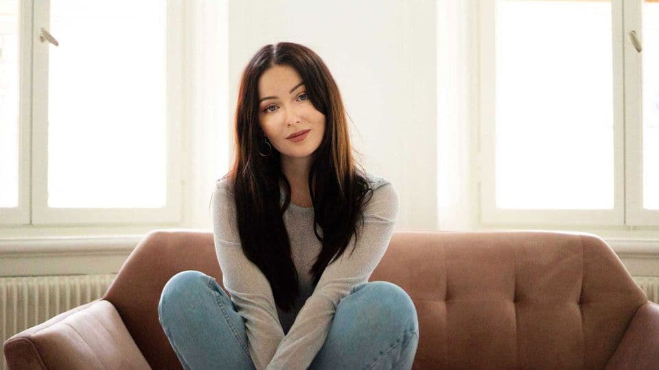 Singer Isa Molin sitting on a couch